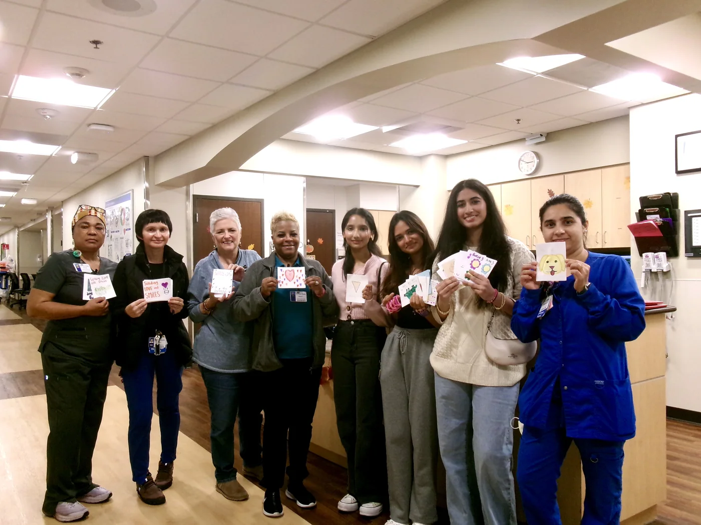 Volunteers and hospital staff holding handmade cards for cardiac patients.