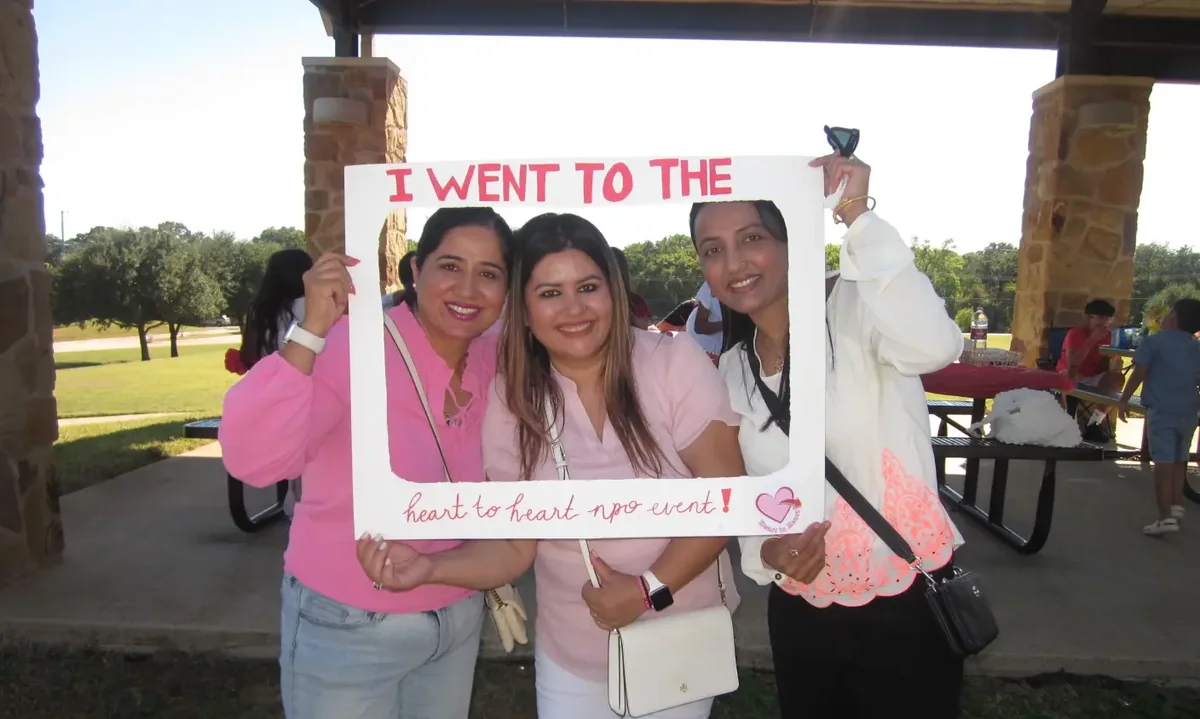 Three Heart to Heart volunteers at a community event photo booth.